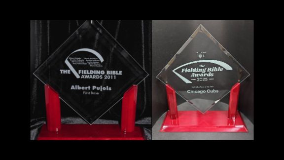 Fielding Bible Award glass trophies on a red base. The trophies are diamond shaped and say The Fielding Bible Awards. One has the name Albert Pujols on it. The other has the Chicago Cubs on it.